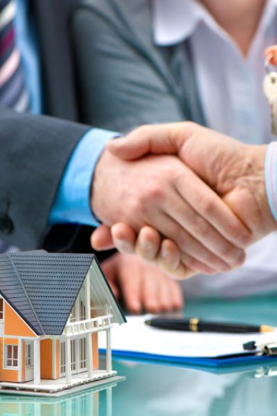 Estate agent shaking hands with customer after contract signature